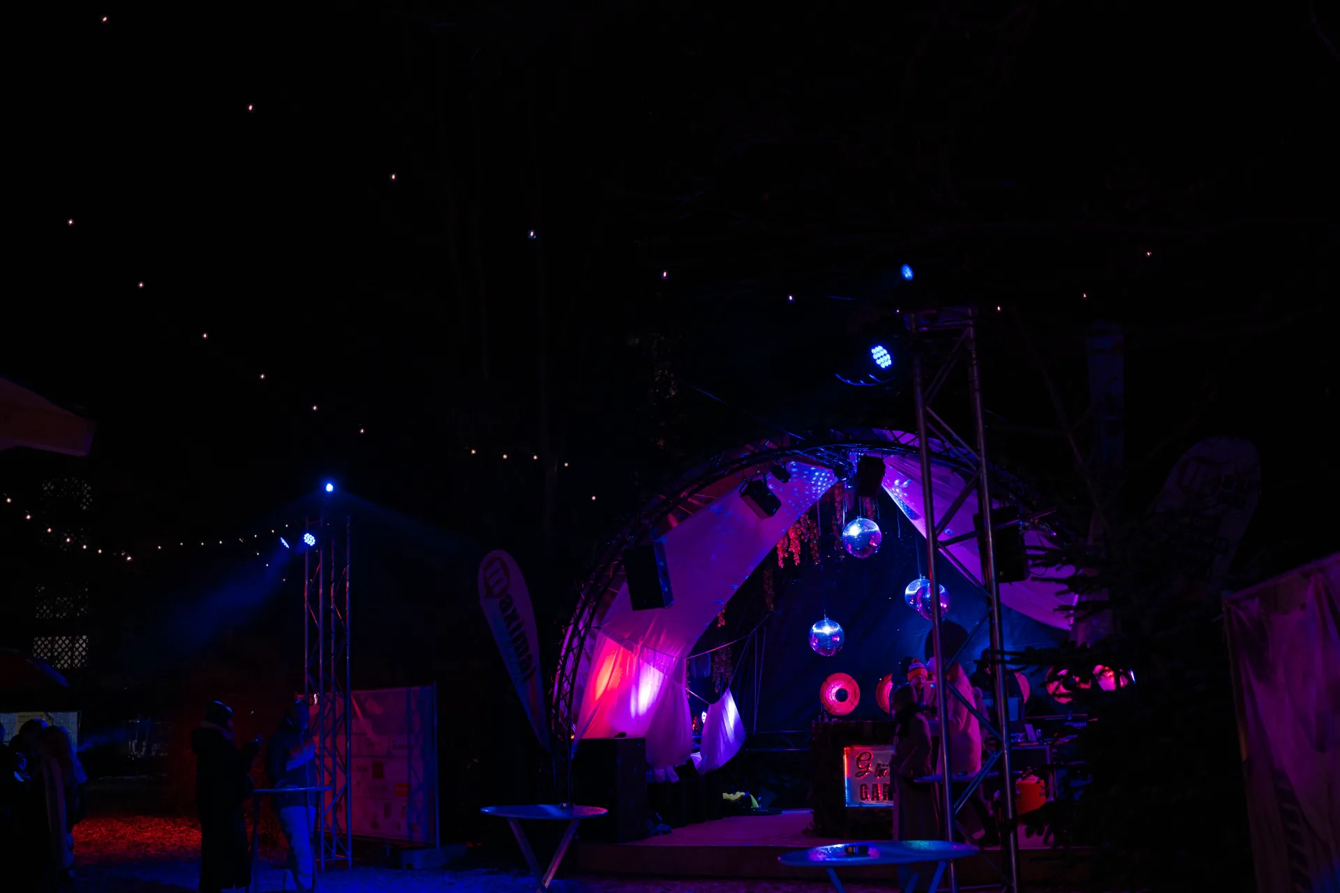 Outdoor-Bühne mit Discokugeln und lila Beleuchtung unter Sternenhimmel