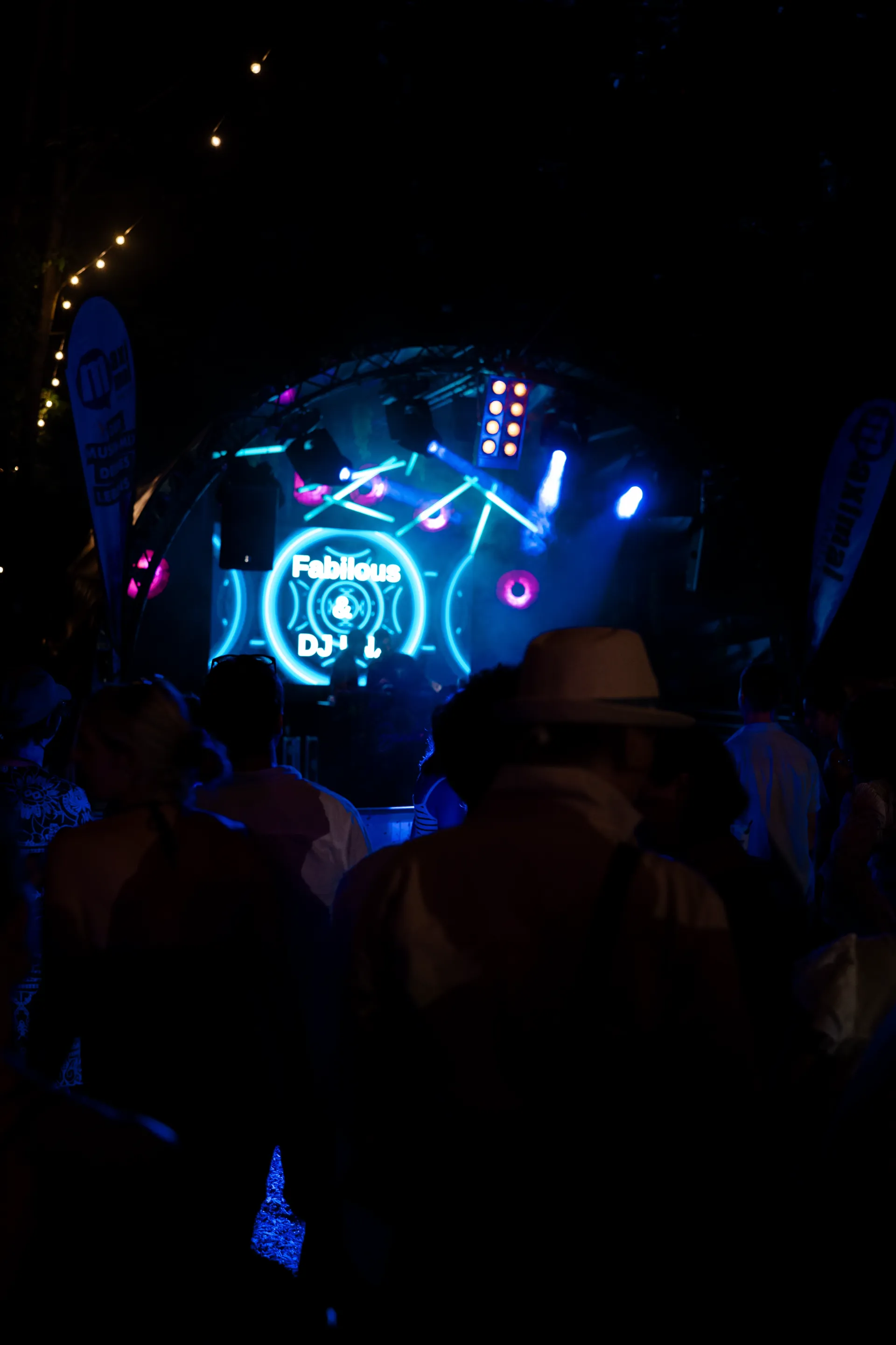 Festival-Crowd vor blauer Bühne mit Lichtshow